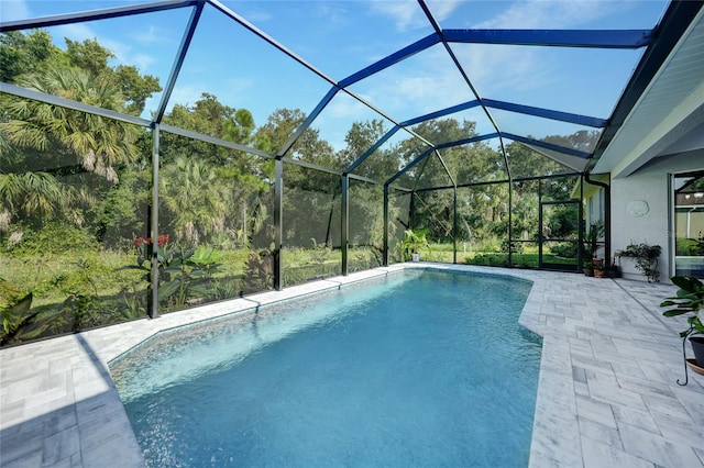 view of swimming pool featuring glass enclosure and a patio