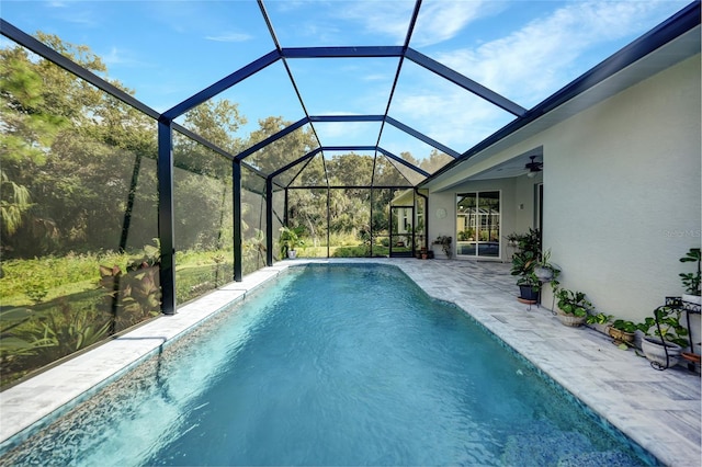 view of swimming pool featuring ceiling fan, a patio area, and a lanai