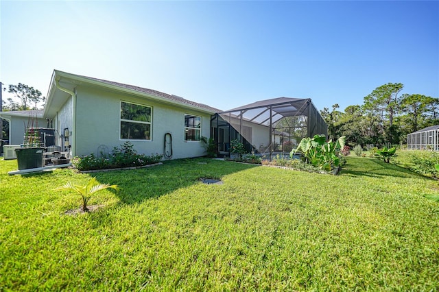 rear view of property with a lawn and glass enclosure