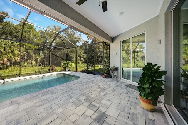 view of pool featuring glass enclosure, ceiling fan, and a patio area