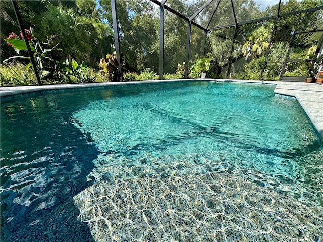 view of swimming pool featuring glass enclosure