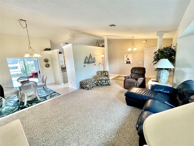 carpeted living room with a chandelier, ornate columns, a textured ceiling, and vaulted ceiling