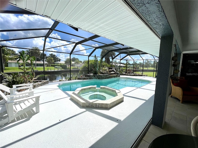 view of pool with an in ground hot tub, a patio, a water view, and a lanai