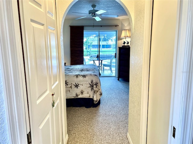 bedroom featuring light carpet, a textured ceiling, access to exterior, and ceiling fan