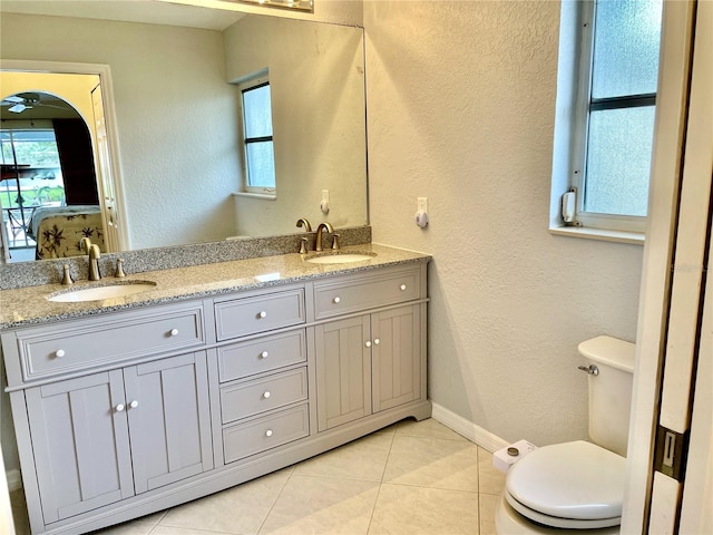 bathroom featuring toilet, plenty of natural light, vanity, and tile patterned flooring