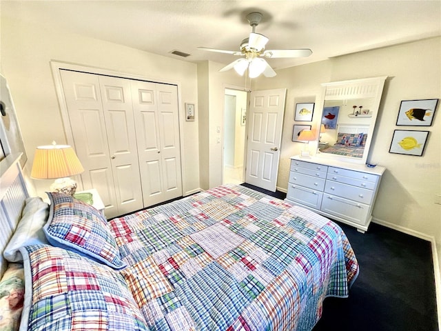 bedroom with ceiling fan, dark carpet, a textured ceiling, and a closet