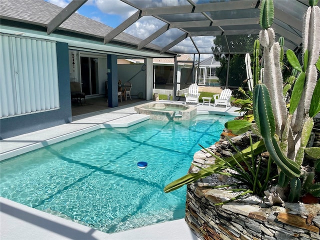 view of pool with a lanai, a patio area, and an in ground hot tub