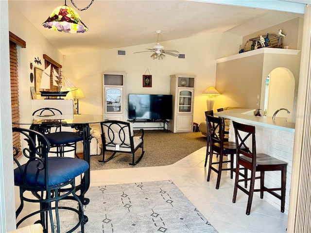 tiled living room with ceiling fan, lofted ceiling, and sink