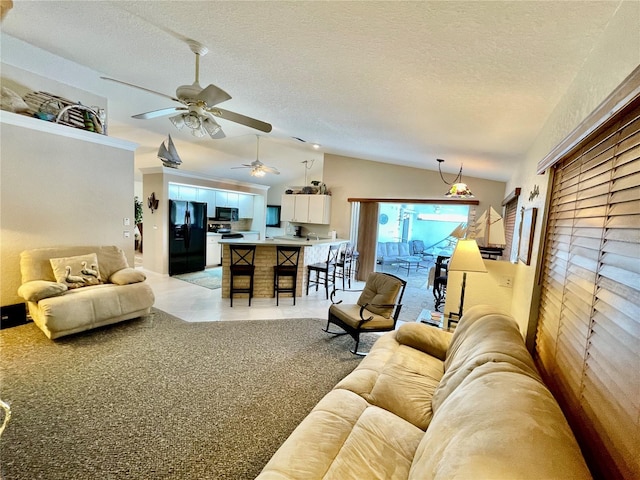 living room with a textured ceiling, light colored carpet, ceiling fan, and lofted ceiling