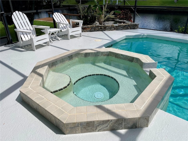 view of swimming pool featuring an in ground hot tub, a patio, and a water view