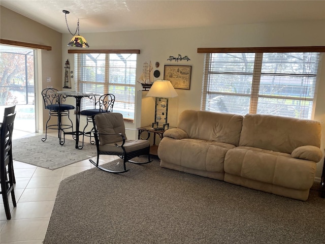 living room with light tile patterned floors, plenty of natural light, and lofted ceiling