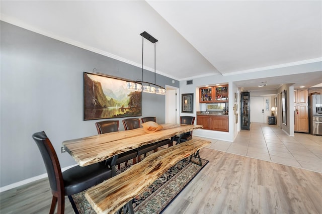 dining room with light hardwood / wood-style flooring and ornamental molding