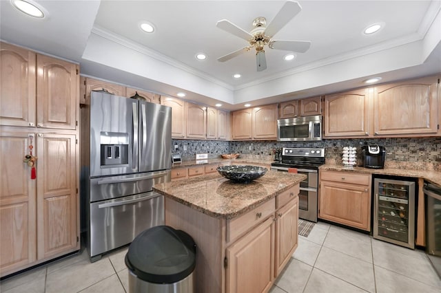 kitchen with appliances with stainless steel finishes, light stone counters, light tile patterned floors, a center island, and beverage cooler