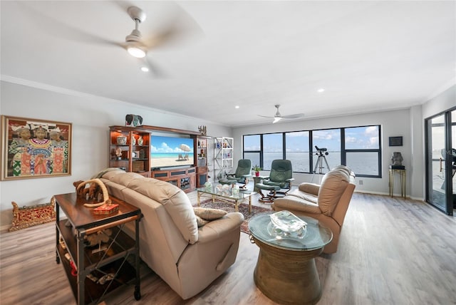 living room featuring ornamental molding, light hardwood / wood-style floors, and ceiling fan