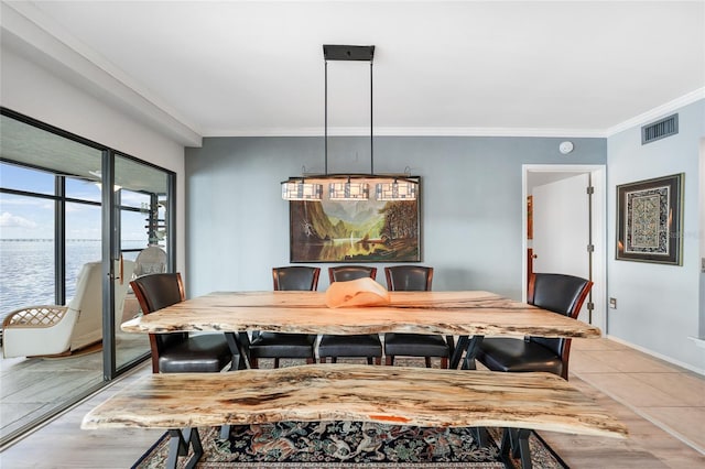 dining room featuring a water view, ornamental molding, and light hardwood / wood-style flooring