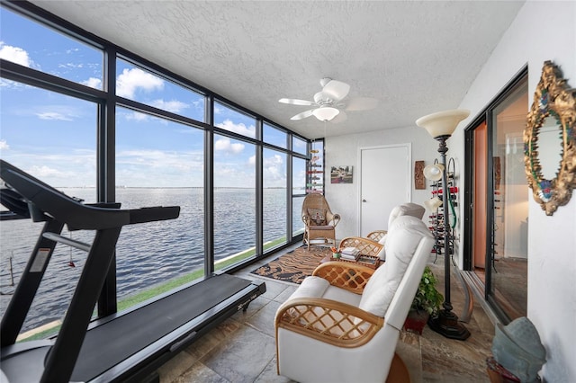 sunroom with a water view and ceiling fan