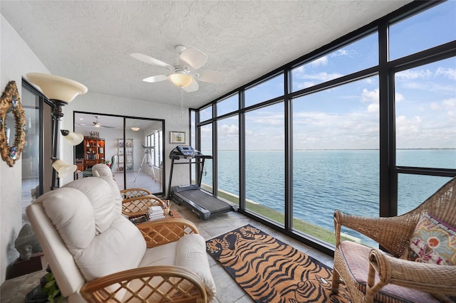 sunroom with a water view and ceiling fan