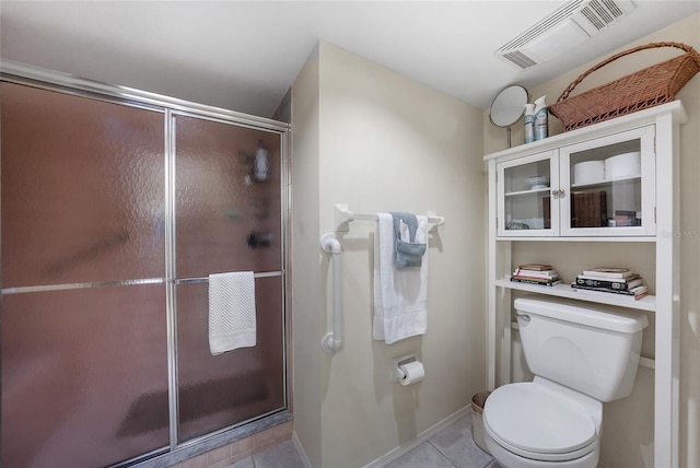 bathroom with tile patterned flooring, walk in shower, and toilet