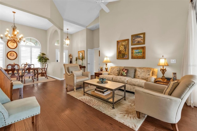 living room featuring ceiling fan with notable chandelier, dark hardwood / wood-style floors, and high vaulted ceiling