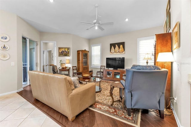 living room featuring light wood-type flooring, ceiling fan, and plenty of natural light