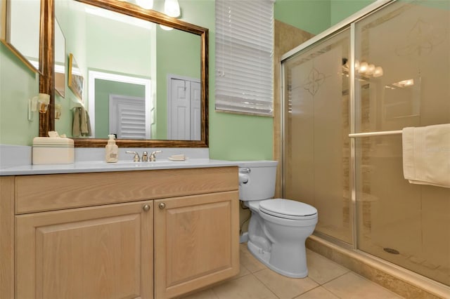 bathroom with tile patterned floors, walk in shower, vanity, and toilet