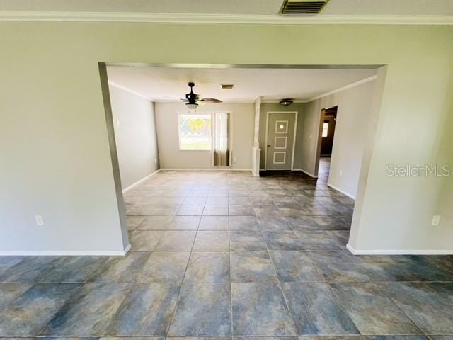 tiled spare room featuring ceiling fan and ornamental molding