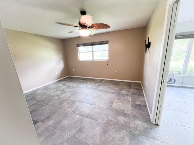 unfurnished room with ceiling fan and plenty of natural light