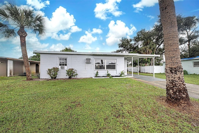 single story home with a wall mounted air conditioner, a front lawn, and a carport