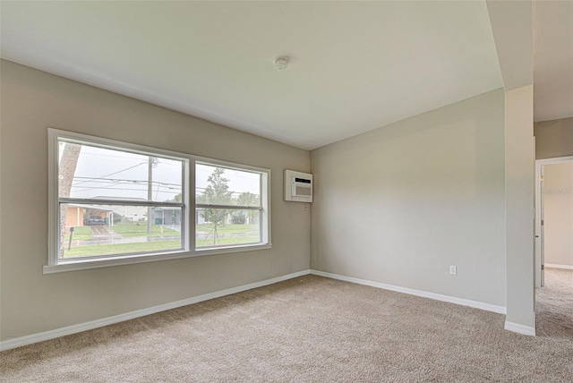 carpeted spare room featuring a healthy amount of sunlight and a wall unit AC