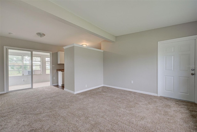 carpeted empty room with beamed ceiling