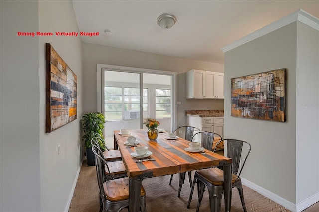 carpeted dining area with crown molding