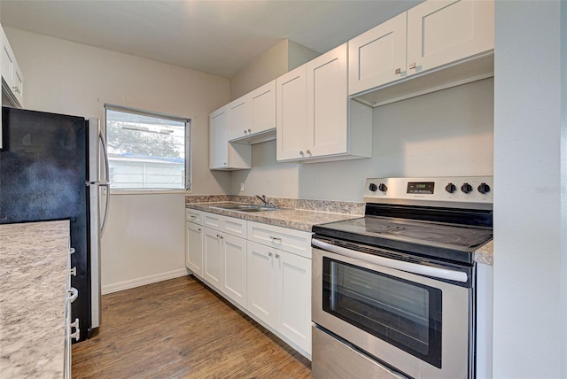 kitchen with wood-type flooring, appliances with stainless steel finishes, sink, and white cabinetry