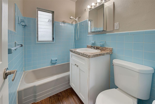 full bathroom featuring tile walls, wood-type flooring, vanity, and toilet