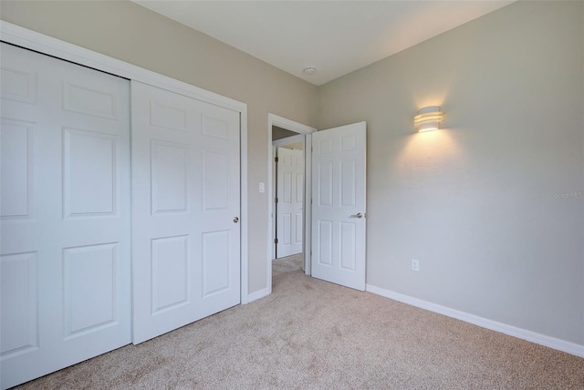 unfurnished bedroom with light carpet and a closet