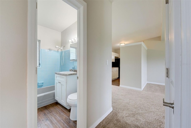 full bathroom with hardwood / wood-style flooring, vanity, toilet, and tiled shower / bath