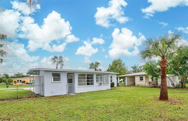 rear view of property featuring a yard and a sunroom