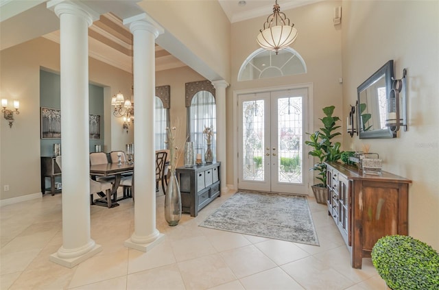 foyer with a notable chandelier, light tile patterned floors, ornamental molding, a high ceiling, and french doors