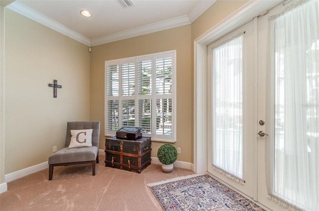 living area with ornamental molding, carpet, and plenty of natural light