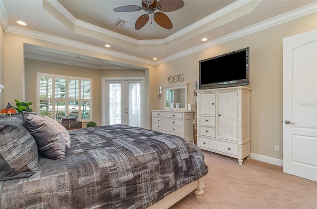 carpeted bedroom with ceiling fan, ornamental molding, and a tray ceiling