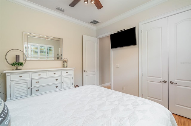 bedroom with light hardwood / wood-style floors, a closet, crown molding, and ceiling fan