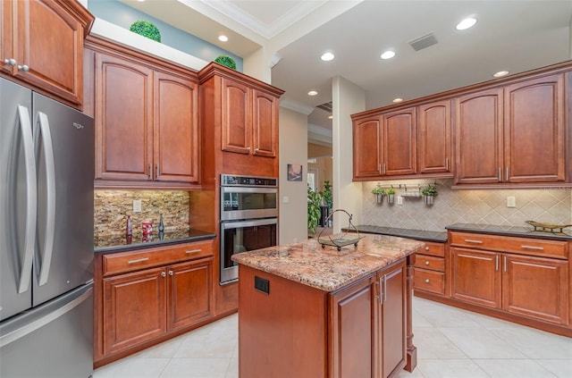 kitchen with backsplash, ornamental molding, dark stone countertops, light tile patterned flooring, and stainless steel appliances