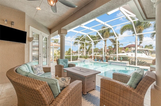 exterior space featuring a patio, a lanai, ceiling fan, an outdoor living space, and a jacuzzi