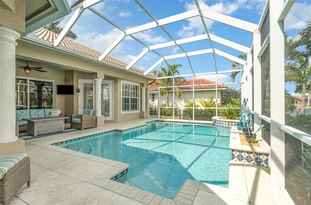 view of pool with a patio, ceiling fan, glass enclosure, and outdoor lounge area