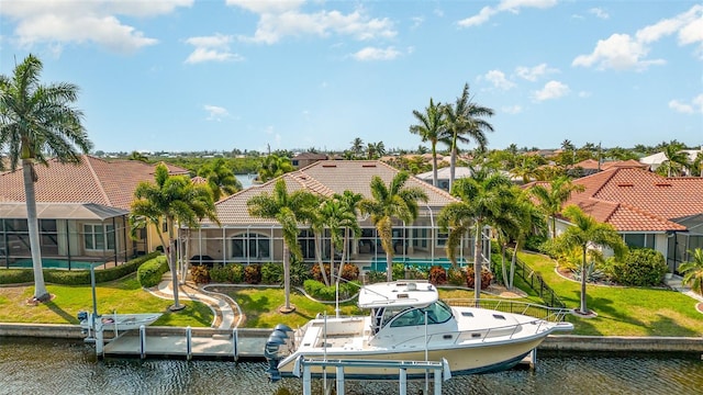 rear view of property with a yard, a water view, and glass enclosure