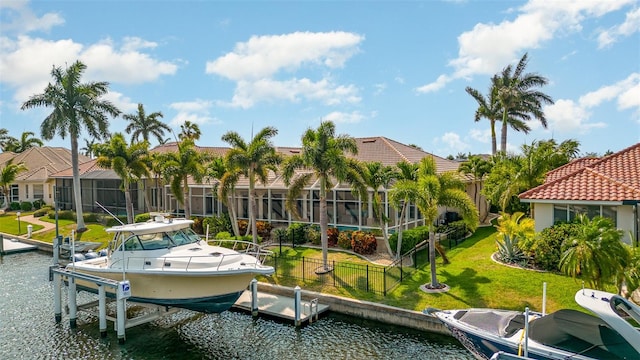 dock area with a yard, a water view, and a lanai