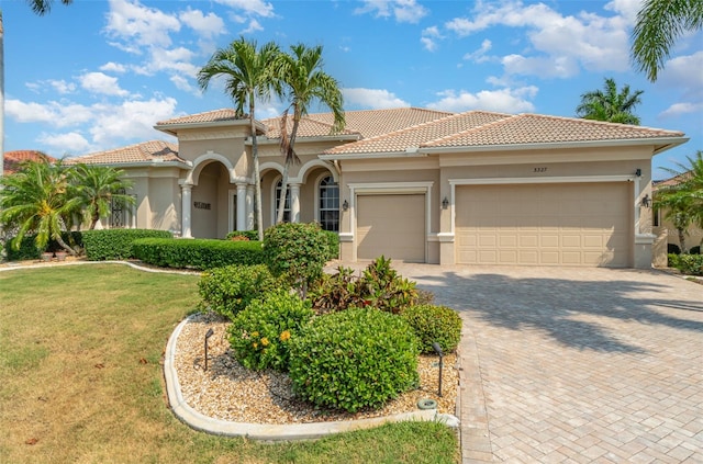 mediterranean / spanish house with a front lawn and a garage