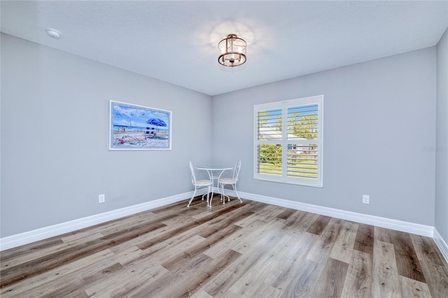 unfurnished room featuring light wood-type flooring and a textured ceiling