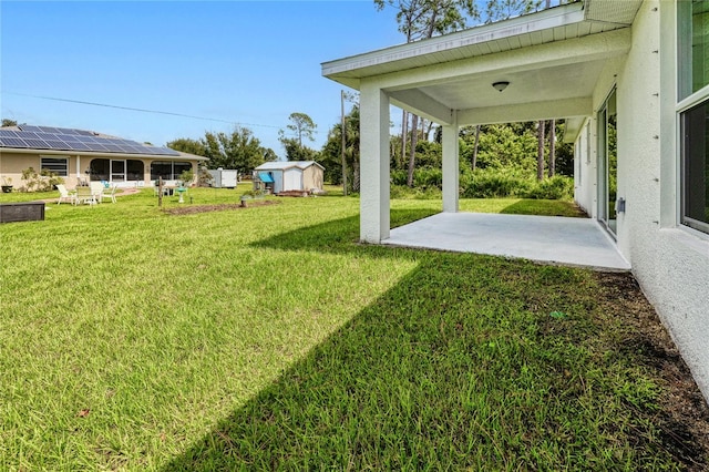 view of yard featuring a storage unit and a patio