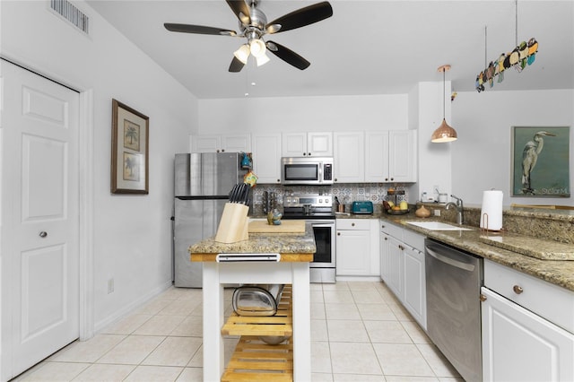 kitchen featuring sink, white cabinets, stainless steel appliances, decorative light fixtures, and ceiling fan