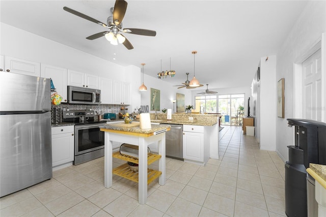 kitchen with stainless steel appliances, white cabinetry, ceiling fan, and hanging light fixtures